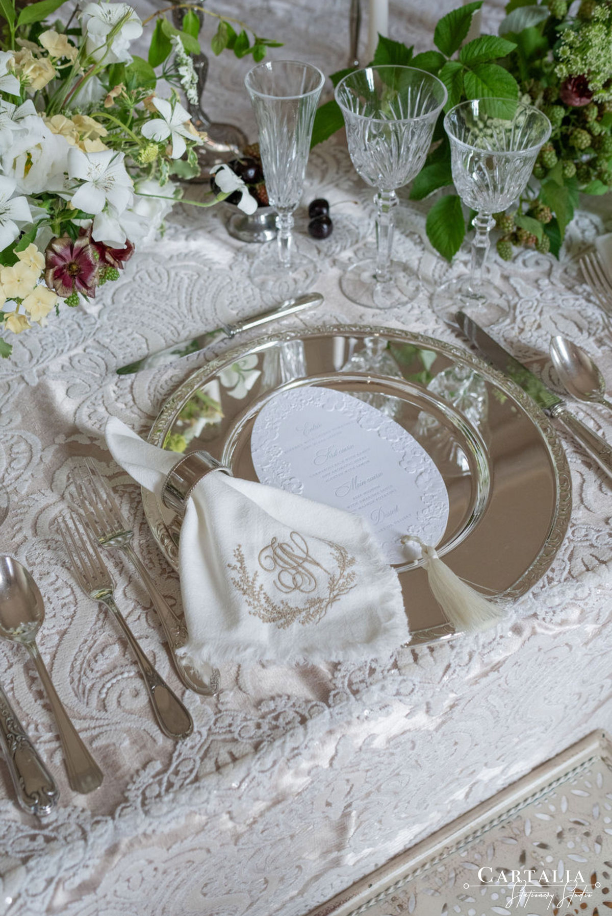 3D Sculped Menu with Letter press Elegant table setting with white flowers, silverware, and a monogrammed napkin.