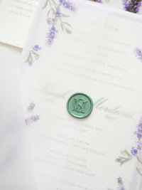 Invito a nozze color oliva e lavanda con monogramma verde e sigillo in ceralacca