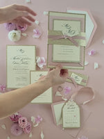 Suite di invito a strati con glitter dorati con etichetta monogramma e nastro con fascia per la pancia