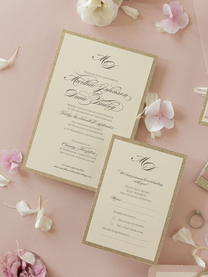 Suite di invito a strati con glitter dorati con etichetta monogramma e nastro con fascia per la pancia